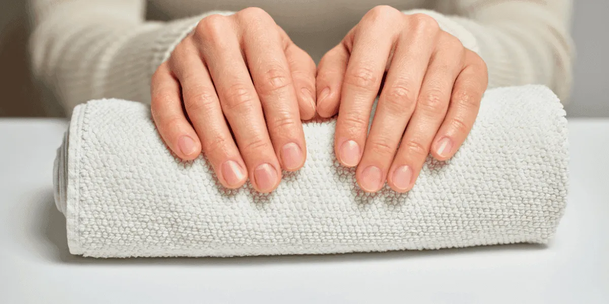 Mani femminili curate con unghie sane e forti al naturale, simbolo di benessere e bellezza.